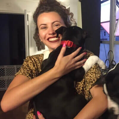 Image of white woman holding a black puppy